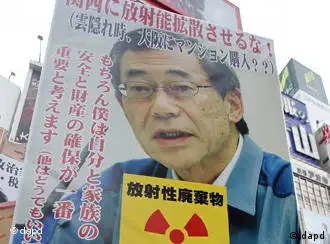 An anti-nuclear demonstrator holds a portrait of outgoingTokyo Electric Power Co.