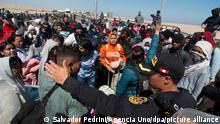 Ein peruanischer Polizist sperrt Migranten den Weg an der Grenze zwischen Chile und Peru. Die Migranten warten seit Tagen in der Wüste im Norden von Chile darauf, die Grenze nach Peru überqueren zu dürfen. Sie wollen in ihre Heimatländer zurück, so die Behauptung lokaler Medien gegenüber. Chile versucht gleichzeitig, rechtlich gegen Migranten ohne gültige Papiere vorzugehen. +++ dpa-Bildfunk +++