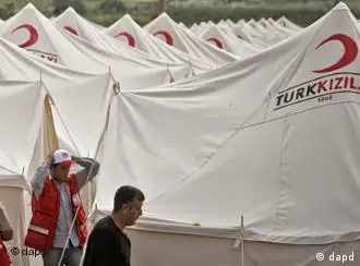 Turkish Red Crescent worker are seen in an almost completed new refugee tent camp in Boynuyogun, Turkey, near the Syrian border, Saturday, June 11, 2011. In the Turkish border town of Yayladagi, authorities set up four field hospitals, each with a 10-bed capacity, for emergency cases. Most of the nearly 50 Syrians, who were wounded in clashes in Jisr al-Shugour or elsewhere recently, are being treated at the state hospital in the Turkish city of Hatay.(Foto:Vadim Ghirda/AP/dapd)