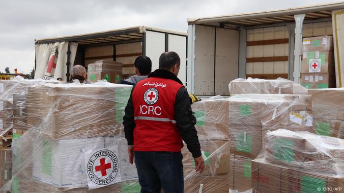 Comité Internacional de la Cruz Roja en Ammán, Jordania: un hombre con chaleco de la Cruz Roja delante de paquetes envueltos en papel de aluminio.