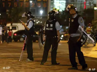 Chinese police officers in anti-riot gear patrol the streets of Xintang in southern China's Guangdong province, Tuesday, June 14, 2011. Security forces patrolled the streets and manned roadblocks Tuesday in the southern Chinese city where rioting factory workers attacked police stations and torched vehicles over the weekend, residents said. (Foto:AP/dapd) CHINA OUT