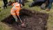 A man with a shovel digs at a possible location