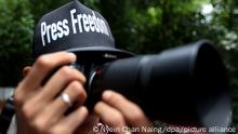 epa03367764 A Myanmar journalist wears a black cap that reads 'Press Freedom' as he take a picture in front of the Dagon Township court, Yangon, Myanmar, 23 August 2012. Myanmar journalists wear the black T-Shirts and black caps that read the 'Press Freedom' and 'Stop Killing Press' to show their unity. Myanmar's government claims it abolished media censorship on 20 August 2012, but The Voice Weekly journal and The Snap Shot News journal have been on trial for their news articles. EPA/NYEIN CHAN NAING ++