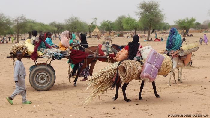 Una familia con burros y un carro improvisado avanzan huyendo de los combates.