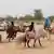 Sudanese refugees ride donkeys towards the boundary with Chad