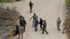 Uma imagem aérea mostra soldados da Guarda Nacional e da Patrulha de Fronteira abordando migrantes que tentam entrar nos Estados Unidos.