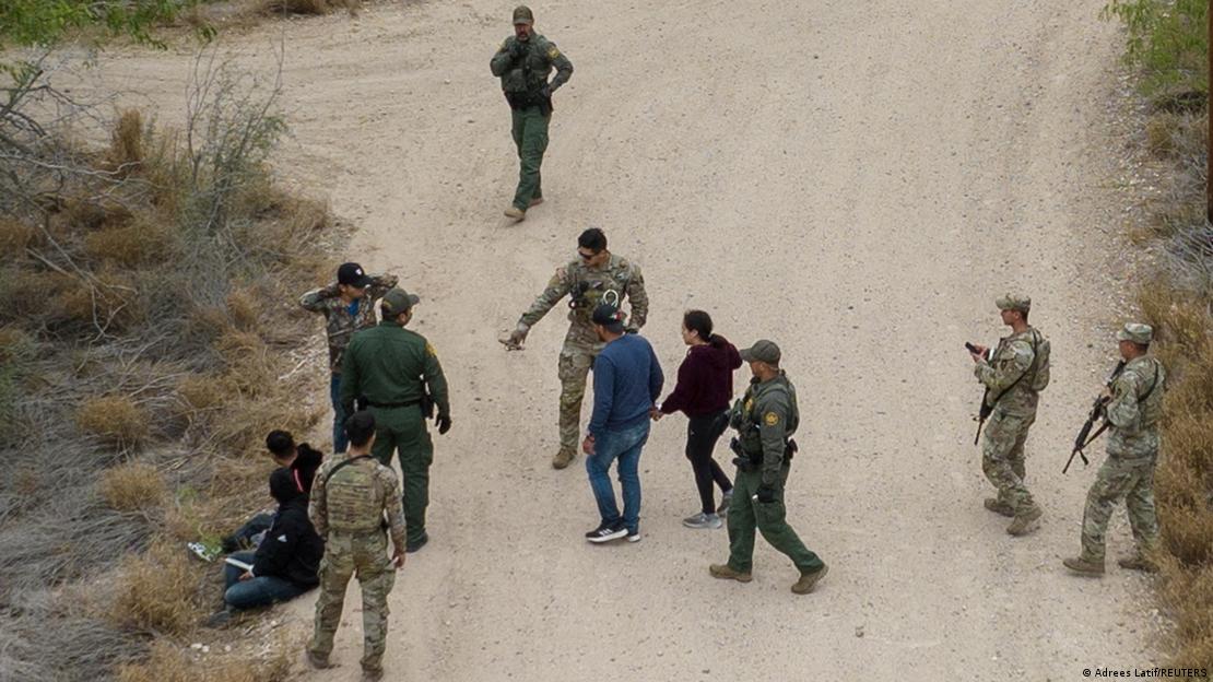 Uma imagem aérea mostra soldados da Guarda Nacional e da Patrulha de Fronteira abordando migrantes que tentam entrar nos Estados Unidos. Uma imagem aérea mostra soldados da Guarda Nacional e da Patrulha de Fronteira abordando migrantes que tentam entrar nos Estados Unidos.