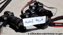 28.06.2021
Photojournalists leave their cameras on the ground with a note reading in Arabic Freedom of Press during a protest outside the United Nations office in the occupied West Bank city of Ramallah on June 28, 2021, demanding protection following attacks by Palestinian security forces on their colleagues. - Demonstrations against the PA erupted on June 24 following the violent arrest and death in custody of activist Nizar Banat.
The Palestinian Journalists Syndicate called for the dismissal of the PA police chief due to the police's failure to protect journalists who were attacked, prevented from reporting and threatened within view of police officers at the protests. (Photo by ABBAS MOMANI / AFP) (Photo by ABBAS MOMANI/AFP via Getty Images)