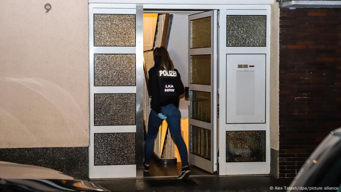 Eine Polizistin geht in ein Haus