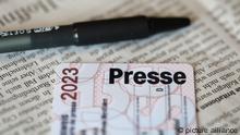 Ein Presseausweis liegt auf einer gedruckten Tageszeitung.