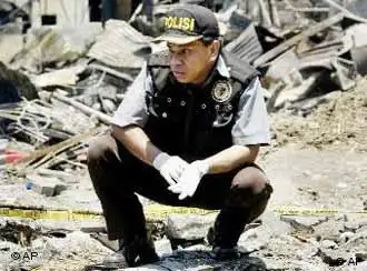 An Indonesian police officer surveys the ruins of a nightclub after a bomb blast destroyed the club, killing more than 180 people and injuring more than 300 others in Denpasar, Bali, Indonesia, Sunday, Oct. 13, 2002. A second bomb exploded about 100 meters (yards) from the U.S. consular office in Denpasar, the capital of Bali, said Lt. Col. Yatim Suyatno, a police spokesman