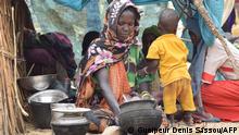 01.05.2023****A Sudanese refugee who crossed into Chad cooks a meal in a makeshift shelter at a camp in Koufroun, near Echbara, on May 1, 2023. - Hundreds of Sudanese, most of them women and children, each day cross a small, dry stream to find safety in neighbouring Chad. At least 20,000 people had found refuge at a makeshift camp in the Chadian border village of Koufroun, according to the United Nations refugee agency UNCHR, which manages their influx along with other UN agencies. (Photo by Gueipeur Denis SASSOU / AFP)