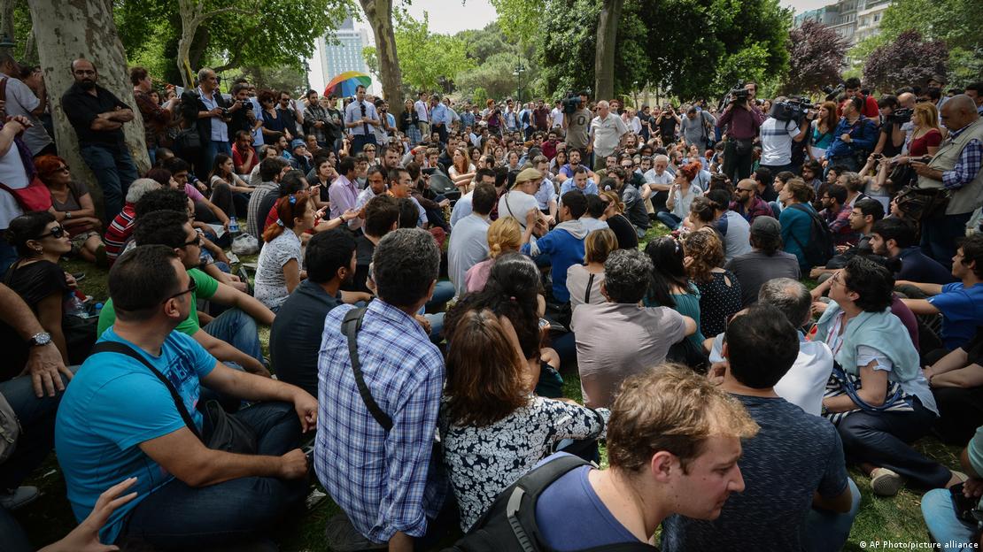 A crowd of peeople sitting in protest at Gezi Park