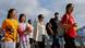 Mainland Chinese tourists walk in front of the skyline of buildings at Tsim Sha Tsui, in Hong Kong Mainland Chinese tourists walk in front of the skyline of buildings at Tsim Sha Tsui, in Hong Kong