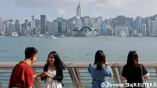 02/05/2023**Mainland Chinese tourists take photo of the skyline of buildings at Tsim Sha Tsui, in Hong Kong, China May 2, 2023. REUTERS/Tyrone Siu