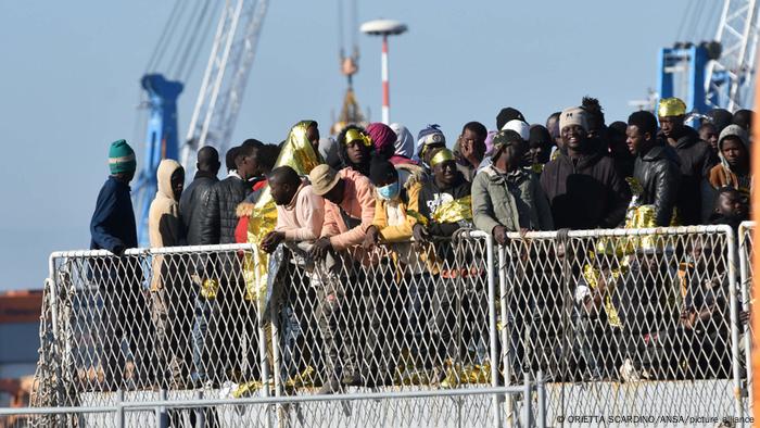 Migrantes esperando para desembarcar de un barco.