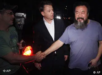 Activist artist Ai Weiwei, right, shakes hand with unidentified foreign journalists gathered outside his home in Beijing, China, Wednesday, June 22, 2011. Chinese state media said Ai Weiwei has been released on bail after confessing to tax evasion, following three month in detention. Ai thanked reporters waiting outside his studio for their support but said under the conditions of his release he was not able to say more.(Foto:Ng Han Guan/AP/dapd)