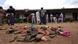 A pile of sandals and a group of Nigerian adults standing in front of a school A pile of sandals and a group of Nigerian adults standing in front of a school