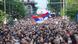 Bandeira da Sérvia em meio à multidão de pessoas durante protesto em Belgrado em reação aos recentes tiroteios em massa que abalaram o país. Bandeira da Sérvia em meio à multidão de pessoas durante protesto em Belgrado em reação aos recentes tiroteios em massa que abalaram o país.