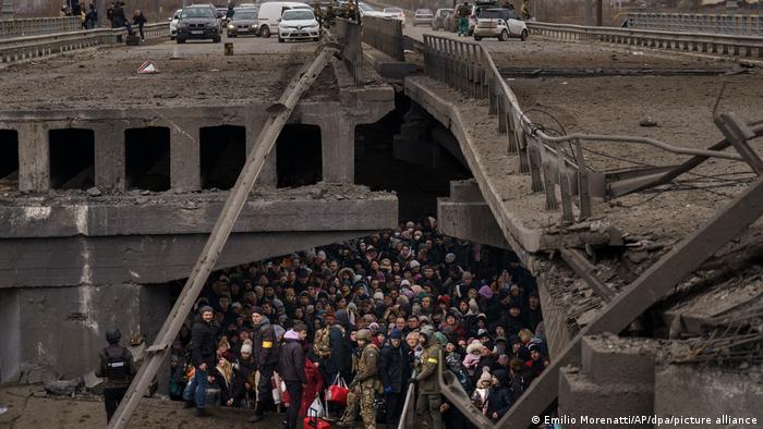 Civiles ucranianos que buscan protección bajo un puente casi destruido.