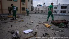Palestinian paramedics inspect damage in a building following Israeli airstrikes on an apartment of an Islamic Jihad commander in Gaza City, Tuesday, May 9, 2023. The Israeli military says it has killed three senior commanders of the militant Islamic Jihad group in targeted airstrikes. Palestinian health officials said 13 people were killed in total in Tuesday's attacks, including the commanders, their wives, several of their children and others nearby. (AP Photo/Fatima Shbair)