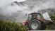 A refrigerator is moved by tractor past a mountain wreathed in fog A refrigerator is moved by tractor past a mountain wreathed in fog
