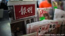 A copy of Hong Kong based newspaper Ming Pao (top L) is displayed at a convenience store in Hong Kong on December 17, 2015. Shares in the owner of Hong Kong-based newspaper Ming Pao shot up on December 17 on rumours that Chinese Internet giant Alibaba was in talks to buy it, days after it snapped up the city's South China Morning Post. AFP PHOTO / ANTHONY WALLACE (Photo by ANTHONY WALLACE / AFP)