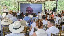 09/05/2023 People look at a screen with the image of Salvatore Mancuso, former commander of the right-wing paramilitary group United Self-Defenses of Colombia (AUC), during a ceremony at a cremation chamber where paramilitary groups disappeared their victims during the armed conflict, in the area of Juan Frio in the municipality of Villa del Rosario, Colombia on May 9, 2023. (Photo by Schneyder Mendoza / AFP)