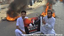Supporters of Pakistan's former Pakistan's former Prime Minister Imran Khan hold a banner of their leader next to burning tires during a protest to condemn the arrest of their leader, in Hyderabad, Pakistan, Tuesday, May 9, 2023. Khan was arrested Tuesday as he appeared in a court in the country’s capital, Islamabad, to face charges in multiple graft cases. Security agents dragged Khan outside and shoved him into an armored car before whisking him away. (AP Photo/Pervez Masih)