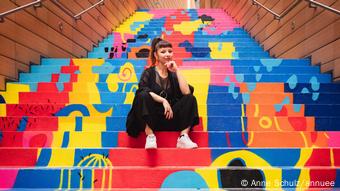 Artista colombiana posa junto a su obra multicolor sobre la escalera de Potsdamerplatz en Berlín.
