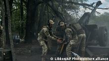 12.05.2023, Ukraine, Bachmut: Ukrainische Soldaten feuern eine Kanone in der Nähe von Bachmut in der Region Donezk ab. Foto: LIBKOS/AP/dpa +++ dpa-Bildfunk +++