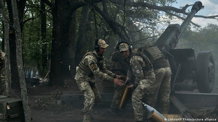 Ukrainische Soldaten feuern eine Kanone ab