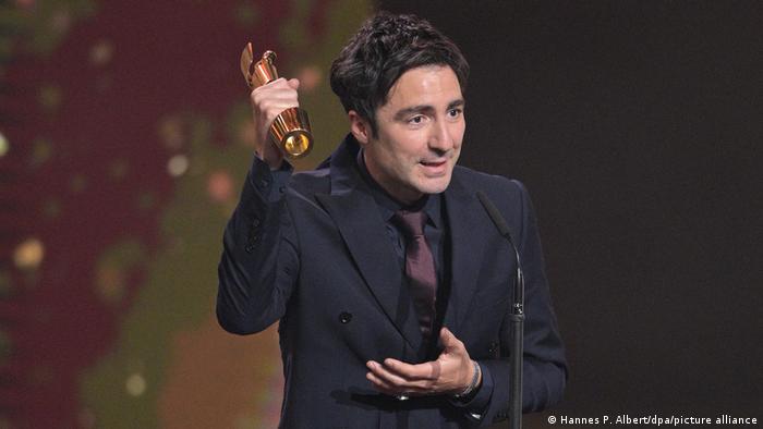Ilker Catak steht bei der Verleihung des Deutschen Filmpreises mit dem Preis für die beste Regie für Das Lehrerzimmer auf der Bühne.