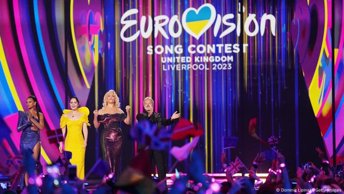 Drei Frauen und ein Mann moderieren zusammen auf der ESC-Bühne. Drei Frauen und ein Mann moderieren zusammen auf der ESC-Bühne.