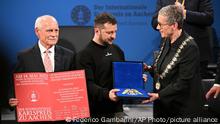 Ukrainian President Volodymyr Zelenskyy, center, receives the Charlemagne Prize for Services to European Unity from the Lord Mayor of Aachen Sibylle Keupen, right, in Aachen, Germany, Sunday, May 14, 2023. Zelenskyy is in Aachen to receive the International Charlemagne Prize, awarded to him and the people of Ukraine. (Federico Gambarini/DPA via AP, Pool)