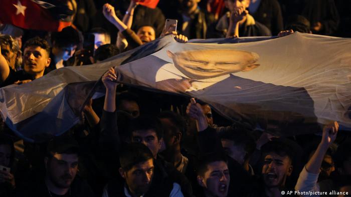 Unterstützer von Kemal Kilicdaroglu halten Fahne mit seinem Gesicht darauf hoch