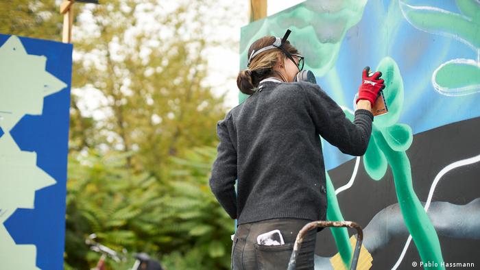 La artista chilena Rommy González pintando con aerosoles en el marco del Festival Al aire, libres de Berlín.