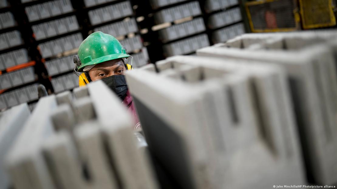 Trabalhadores monitoram uma linha de produção de blocos de concreto feitos com dióxido de carbono líquido.