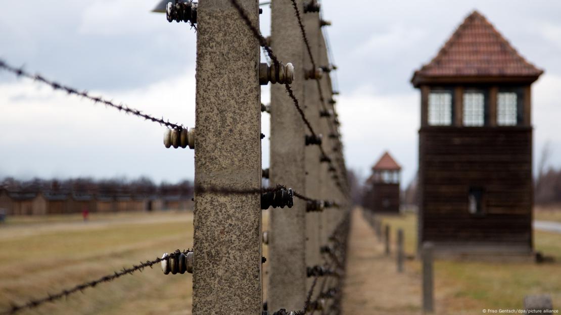 Ein Zaun und Wachtürme im Gelände des ehemaligen deutschen KZ