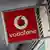 A Vodafone logo is pictured on a sign above a store in central London
