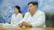Kim Jong Un and his daughter Kim Ju Ae in white lab coats speaking to the media. 