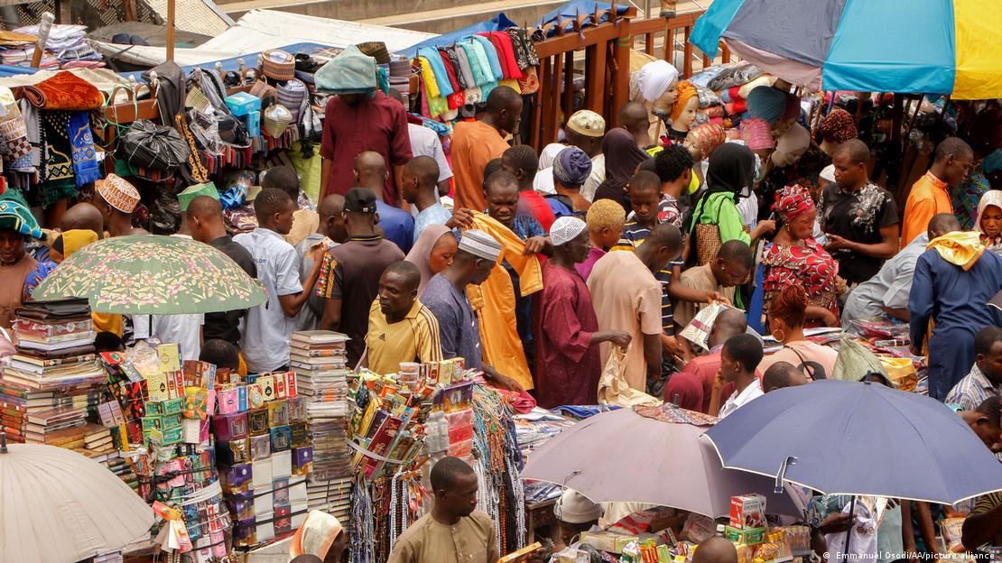Dozens of people mingle at a colorful bazaar in Lagos
