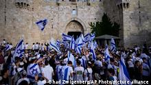 Israelis wave national flags during a march marking Jerusalem Day, an Israeli holiday celebrating the capture of east Jerusalem in the 1967 Mideast war, in front of the Damascus Gate of Jerusalem's Old City, Thursday, May 18, 2023. (AP Photo/Ohad Zwigenberg)