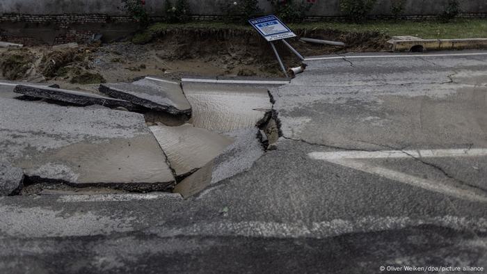 Eine Straße ist nachdem heftige Regenfälle, die Überschwemmungen verursacht hatten, aufgebrochen.