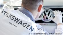 ARCHIV+++ Ein VW-Mitarbeiter säubert am Dienstag (20.10.2009) im Volkswagenwerk im russischen Kaluga das Logo eines Volkswagen-Fahrzeug vom Modell Tiguan. Am Dienstag ist offizieller Produktionsstart für die Vollproduktion der Modelle Volkswagen Tiguan und Skoda Octavia. 3000 Mitarbeiter sollen bis Ende 2010 in dem Werk beschäftigt sein. Das Produktionsziel von 150 000 Fahrzeugen soll, laut Konzernangaben, ab 2010 erzielt werden. Foto: Friso Gentsch dpa +++(c) dpa - Report+++
