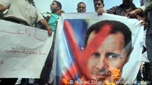 epa03000868 A Syrian protestor burning picture of Syria's President Bashar al-Assad during during a protest before the Arab Foreign Ministers emergency meeting, next to the Arab League Headquarters in Cairo, Egypt, 12 November 2011. Arab foreign ministers meet to discuss the Syrian issue within ten days. The organization said the meeting is held upon a request from Qatar, which heads an Arab League committee on Syria, in view of continued violence and the Syrian government's failure to implement its commitments under the Arab plan to solve the crisis in Syria. EPA/KHALED ELFIQI ++ +++ dpa-Bildfunk +++
