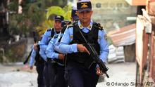 Members of the National Police patrol in Colonia Divanna, Barrio 18 gang territory, in Tegucigalpa on March 17, 2023. - Armed with rifles, a dozen policemen enter a hillside slum in the Honduran capital to detain gang members, emulating the raids of President Neyib Bukele in El Salvador. To combat these feared gangs, since December 6, 2022 a state of emergency has been in force in Honduras that allows arrests without a warrant. (Photo by Orlando SIERRA / AFP)
