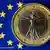 Italian euro coin against a backdrop of a European flag