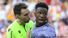Referee Ricardo De Burgos Bengoetxea, left, speaks with Real Madrid's Vinicius Junior during a Spanish La Liga soccer match between Valencia and Real Madrid, at the Mestalla stadium in Valencia, Spain, Sunday, May 21, 2023. The game was temporarily stopped when Vinicius said a fan had insulted him from the stands. He was later sent off after clashing with Valencia players. (AP Photo/Alberto Saiz)