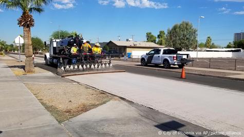 Varios trabajadores colocan un "pavimento fresco" de color más claro para ayudar a combatir los impactos del calor, en Phoenix, Arizona, EE. UU. Varios trabajadores colocan un "pavimento fresco" de color más claro para ayudar a combatir los impactos del calor, en Phoenix, Arizona, EE. UU.